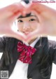 A young woman making a heart shape with her hands.