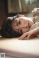 A young girl laying on a bed looking at the camera.