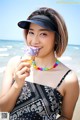 A woman in a black and white dress eating an ice cream cone.