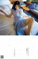 A woman in a blue dress laying on a bed.