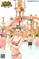 A woman in a pink bikini standing in a water park.