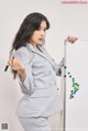 A woman in a business suit writing on a whiteboard.